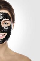 mulher com máscara preta de limpeza profunda no rosto foto