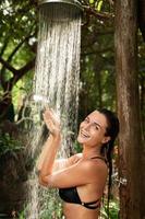 linda mulher tomando banho ao ar livre na selva tropical foto