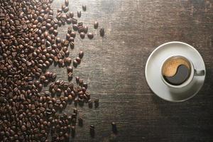 xícara de café com grãos de café na velha mesa foto