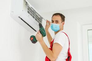técnico masculino limpeza de ar condicionado dentro de casa foto