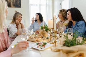 amigos de mulheres jovens bebendo na mesa festiva. foto