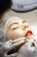 maquiador permanente e seu cliente durante o procedimento de blush labial foto