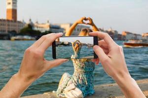 mãos capturando belas paisagens coloridas no smartphone durante viagens ao exterior foto