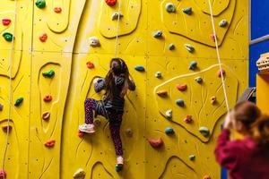 menina escalando parede de pedra foto