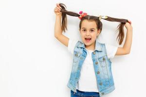 tamanho do corpo inteiro de menina bonita, alegre, adorável, adorável e estilosa, garotinha com tranças encaracoladas em blusa formal, saia azul curta, pensando. isolado sobre o fundo foto