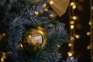 um close-up de enfeites de natal dourados e decorações em uma árvore com um bokeh de fundo foto