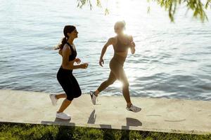 jovem fazendo exercícios de corrida à beira do rio foto