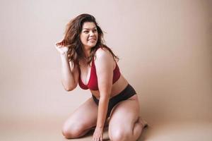 jovem que ama a si mesma plus size em cueca em fundo bege, amor corporal foto