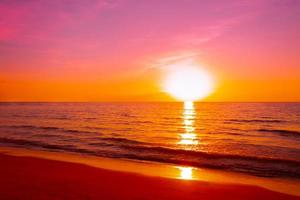 paisagens marinhas do belo céu rosa do sol na praia do mar de férias para viagens foto