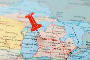 agulha clerical vermelha em um mapa dos eua, michigan e a capital lansing. fechar o mapa de michigan com red tack foto