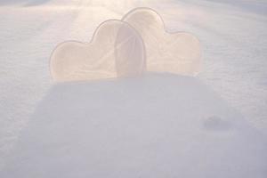 dois corações - um símbolo de amor, feito de gelo, na neve, sob os raios do sol. Dia dos Namorados. conceito romântico. copie o espaço. foto