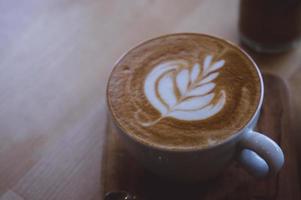 café bebida quente cappucino latte art na mesa vintage de madeira, hora do café no café de fundo de madeira foto