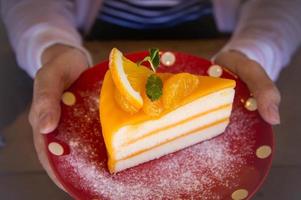 saboroso bolo de frutas laranja no prato vermelho de natal para pronto para comer foto