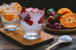 bebida de frutas doces refrigerante de morango e refrigerante de laranja bebida fria vitamina frutas, bebidas saborosas na mesa de madeira foto