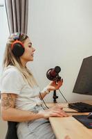 blogueira jovem usando fones de ouvido e microfone condensador durante podcast online foto