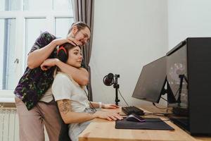 jovem casal se divertindo enquanto joga videogame no computador pessoal foto