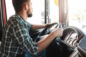 motorista de caminhão masculino dirigindo seu grande veículo foto