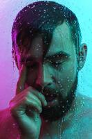 retrato de homem bonito sob o fluxo de água na luz neon foto
