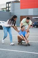 diversos amigos despreocupados se divertindo e andando de longboard no estacionamento foto