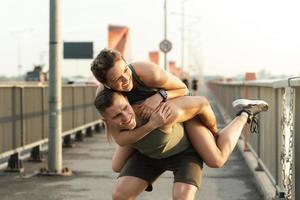 casal de fitness em uma ponte após treino de fitness durante um pôr do sol foto