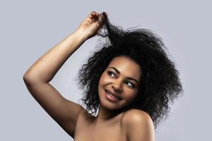 retrato de uma linda mulher negra segurando seu cabelo crespo foto