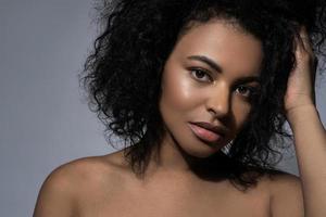linda mulher negra com pele lisa contra fundo cinza foto