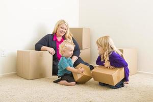 família jovem no quarto vazio com caixas em movimento foto