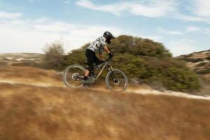 ciclista profissional durante descida em sua bicicleta nas montanhas foto