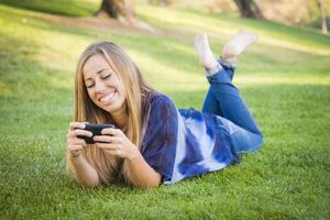jovem sorridente usando telefone celular ao ar livre foto