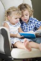 jovem irmão e irmã lendo um livro juntos foto