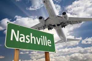 sinal de estrada verde de nashville e avião acima foto