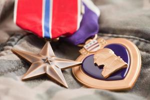 medalhas de bronze e coração roxo em material de camuflagem foto