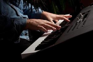 pianista masculino executa no teclado de piano foto