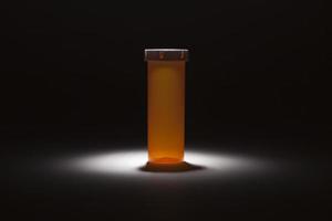 frasco de remédio vazio sob foco de luz foto