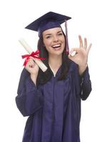 pós-graduação de raça mista em boné e vestido segurando seu diploma foto