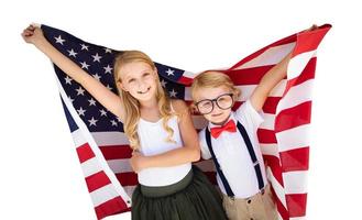 bonito jovem menino cuacasiano e menina segurando a bandeira americana isolada no fundo branco foto