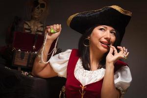 pirata feminina dramática mordendo uma moeda foto