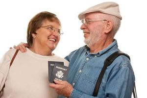 feliz casal sênior com passaportes e malas em branco foto