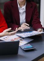 empresário e equipe analisando a tarefa de finanças do balanço financeiro. com telefone inteligente e laptop e tablet. conceito de gestão de riqueza foto