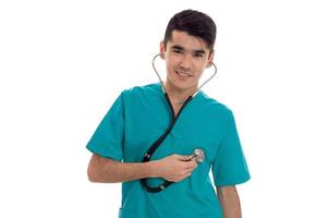 retrato do médico jovem morena bonita de uniforme azul com estetoscópio olhando e sorrindo na câmera isolada no fundo branco foto