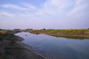canal de vista arial com grama verde e vegetação refletida na água perto do rio padma em bangladesh foto
