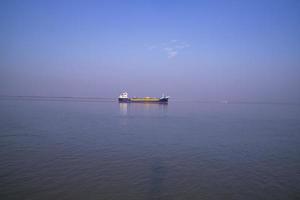 paisagem de um pequeno navio de carga contra um céu azul no rio padma bangladesh foto