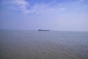 paisagem de um pequeno navio de carga contra um céu azul no rio padma bangladesh foto