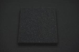 uma esponja preta sobre um fundo preto. borracha de espuma preta em pano preto. o quadrado preto da junta. foto