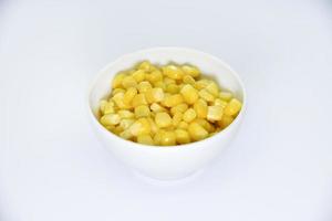 milho maduro em um prato branco. milho amarelo suculento. salada de milho enlatada.
