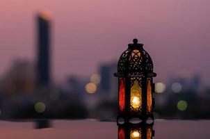 lanterna com céu do amanhecer e fundo claro da cidade bokeh para a festa muçulmana do mês sagrado do ramadã kareem. foto