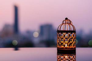 lanternas douradas com céu do amanhecer e fundo claro da cidade bokeh para a festa muçulmana do mês sagrado do ramadã kareem. foto