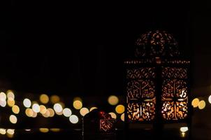 lanterna e tâmaras frutas com luz de bokeh em fundo escuro para a festa muçulmana do mês sagrado do ramadã kareem. foto