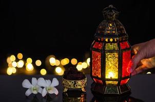 lanterna e tâmaras frutas com flor de orquídea branca em bokeh de fundo claro para a festa muçulmana do mês sagrado do ramadã kareem. foto