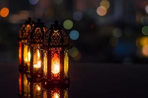 lanternas com céu noturno e cidade bokeh luz de fundo para a festa muçulmana do mês sagrado do ramadã kareem. foto